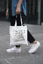 cropped-face-mockup-of-a-man-holding-a-tote-bag-in-the-street-29424.webp